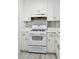 Close up on a vintage style white gas range in an all-white vintage kitchen at 28 Elmora Ave, Goose Creek, SC 29445