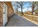 View of a covered concrete patio and fenced in yard with large trees in this charming home at 28 Elmora Ave, Goose Creek, SC 29445
