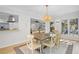 Open-concept dining room with hardwood floors, wood table, and a decorative light fixture near the open kitchen at 2837 Baywood Dr, Seabrook Island, SC 29455