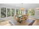 Sunlit dining room featuring hardwood floors, a wood table, and views of lush green trees through large windows at 2837 Baywood Dr, Seabrook Island, SC 29455