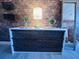 Close up of the dresser in the bedroom with brick accent wall, featuring a lovely lamp and botanical decor at 309 Meeting St # 19, Charleston, SC 29401