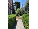 Beautiful landscaped garden featuring a fountain surrounded by trimmed hedges and a brick path at 309 Meeting St # 19, Charleston, SC 29401