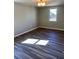 Light filled bedroom featuring dark, modern flooring and a large window at 377 Furman Ln, Ladson, SC 29456