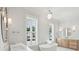 Elegant bathroom featuring a soaking tub, double vanity, modern lighting, and plenty of natural light at 3846 Delinger Dr, Mount Pleasant, SC 29466