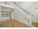 Bright foyer featuring a staircase with white wooden railings and hardwood floors, complemented by large windows at 3846 Delinger Dr, Mount Pleasant, SC 29466