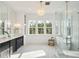 Luxurious bathroom with a modern chandelier, sleek vanity, and a standalone tub at 3866 Delinger Dr, Mount Pleasant, SC 29466