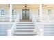 Close up of a beautiful wooden staircase leading to a charming front porch with double front doors at 3866 Delinger Dr, Mount Pleasant, SC 29466