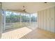 Screened porch showing wood plank floor, ceiling fan, white trim, and serene views of the wooded backyard at 3866 Delinger Dr, Mount Pleasant, SC 29466