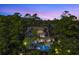 Aerial view of the exterior elevation of a luxurious home with a pool in a wooded area at 4 Falcon Point Rd, Kiawah Island, SC 29455