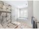 This bathroom boasts a tile shower, a soaking tub by the window, and neutral-toned floor tiles at 4 Falcon Point Rd, Kiawah Island, SC 29455