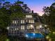 Twilight view of backyard elevation featuring inviting in-ground pool with waterfall feature at 4 Falcon Point Rd, Kiawah Island, SC 29455