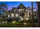 Dusk view of exterior elevation with professionally landscaped front yard and inviting front porch at 4 Falcon Point Rd, Kiawah Island, SC 29455