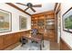 This home office features wood trim, built-in bookshelves, a ceiling fan, and a classic wooden desk and chair at 4 Falcon Point Rd, Kiawah Island, SC 29455