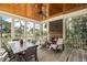 Inviting screened porch with wood ceiling, a dining table, fireplace and outdoor seating with views of the marsh at 4 Falcon Point Rd, Kiawah Island, SC 29455
