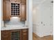 Elegant wine bar featuring custom cabinetry, a wine rack, a wine cooler, and a marble countertop at 4 Falcon Point Rd, Kiawah Island, SC 29455