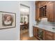 Close up on a wine bar that features wooden cabinetry, a wine rack, a wine cooler, and a marble countertop at 4 Falcon Point Rd, Kiawah Island, SC 29455