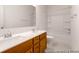 Well-lit bathroom with a double vanity, white countertop, wood cabinets, and a bathtub/shower combo at 409 Avocet Dr # 553P, Summerville, SC 29486