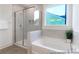 Bright bathroom with a soaking tub, a glass enclosed shower, and tile surround details at 409 Avocet Dr # 553P, Summerville, SC 29486