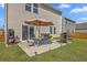 Backyard area with a patio set with umbrella, BBQ, and a lush lawn perfect for outdoor entertaining and relaxation at 4497 Ocean Farm Dr, Summerville, SC 29485