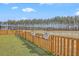 Picturesque backyard overlooking a pond, framed by a charming wooden fence and lush greenery creating a serene outdoor oasis at 4497 Ocean Farm Dr, Summerville, SC 29485