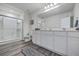 Bright bathroom featuring a glass-enclosed shower, wood-look tile floor and double-sink vanity at 4497 Ocean Farm Dr, Summerville, SC 29485