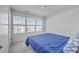 Bright bedroom features neutral carpet, a large window with blinds, and a blue comforter at 4497 Ocean Farm Dr, Summerville, SC 29485