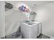 Bright laundry room features a white washer and dryer, overhead shelving and gray storage bin at 4497 Ocean Farm Dr, Summerville, SC 29485