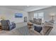 Spacious living room with plush seating, a modern entertainment center, and large windows that bring in natural light at 4497 Ocean Farm Dr, Summerville, SC 29485