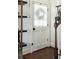 Inviting entryway with hardwood floors and a classic white door with sheer curtain at 51 Gadsden St # B, Charleston, SC 29401