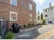 The brick home's exterior is complemented by a well-maintained yard, a black grill, and a paved driveway at 51 Gadsden St # B, Charleston, SC 29401