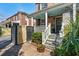 Brick home with a covered porch and inviting entrance, surrounded by greenery and a fenced courtyard at 51 Gadsden St # B, Charleston, SC 29401