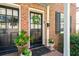 Close-up of front door, showing wreath, potted plants, brick, and an inviting welcome mat at 51 Gadsden St # B, Charleston, SC 29401