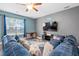 Cozy living room featuring a large blue couch, modern decor, and natural light from the window at 558 Wynfield Forest Dr, Summerville, SC 29485