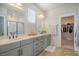 Bright bathroom with double vanity, sleek gray cabinetry, quartz countertop, and walk-in closet at 643 Blueway Ave, Summerville, SC 29486