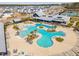 Aerial view of community pool, surrounded by palm trees, lounge seating, and a modern clubhouse at 643 Blueway Ave, Summerville, SC 29486