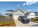 Charming two-story home with attached garage and black SUV in the driveway on a sunny day with blue skies at 643 Blueway Ave, Summerville, SC 29486