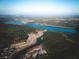 An aerial view captures the beauty of Cane Bay with its river, forest, and community at 747 Maynard Ln, Summerville, SC 29486