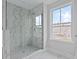 Bright bathroom featuring a glass-enclosed shower with marble tiling and a window for natural light at 747 Maynard Ln, Summerville, SC 29486