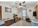 Cozy bedroom with a ceiling fan, light-colored walls, carpet floors and curtains with floral prints at 7753 Linsley Dr, North Charleston, SC 29418