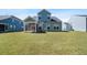 Backyard view of a two-story home with a large lawn and screened-in porch at 804 S Pointe Blvd, Summerville, SC 29483