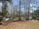 Large backyard with a white picket fence and wooded views beyond the lawn at 9044 Greenbriar Dr, Summerville, SC 29485