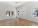 Bright, white living room featuring wood floors, a ceiling fan, and multiple windows at 1014 Alamo St, North Charleston, SC 29405