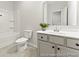 Bathroom featuring a white vanity with sink, toilet, and shower-tub combo, complemented by stylish gray tile flooring at 1024 Drakeford St # 11P, Saint George, SC 29477