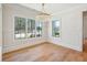 Dining area with hardwood floors, modern chandelier and windows overlooking landscaped yard at 105 Peninsula Dr, Ravenel, SC 29470