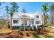 Stylish two-story house featuring a modern white facade, metal roofing, and manicured shrubbery at 105 Peninsula Dr, Ravenel, SC 29470