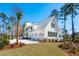 Beautiful home exterior with lush landscaping, metal roof, and a three-car garage at 105 Peninsula Dr, Ravenel, SC 29470