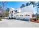 View of this home's exterior, boasting a metal roof, white siding, and 3-car garage at 105 Peninsula Dr, Ravenel, SC 29470