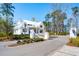 Stunning white farmhouse-style home with a white metal roof and charming gated entrance at 105 Peninsula Dr, Ravenel, SC 29470