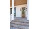 Inviting front entrance with brick steps, wooden door, and stylish wall-mounted lantern sconces at 105 Peninsula Dr, Ravenel, SC 29470