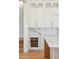 Kitchen detail featuring built in wine fridge and marble backsplash behind white cabinets at 105 Peninsula Dr, Ravenel, SC 29470